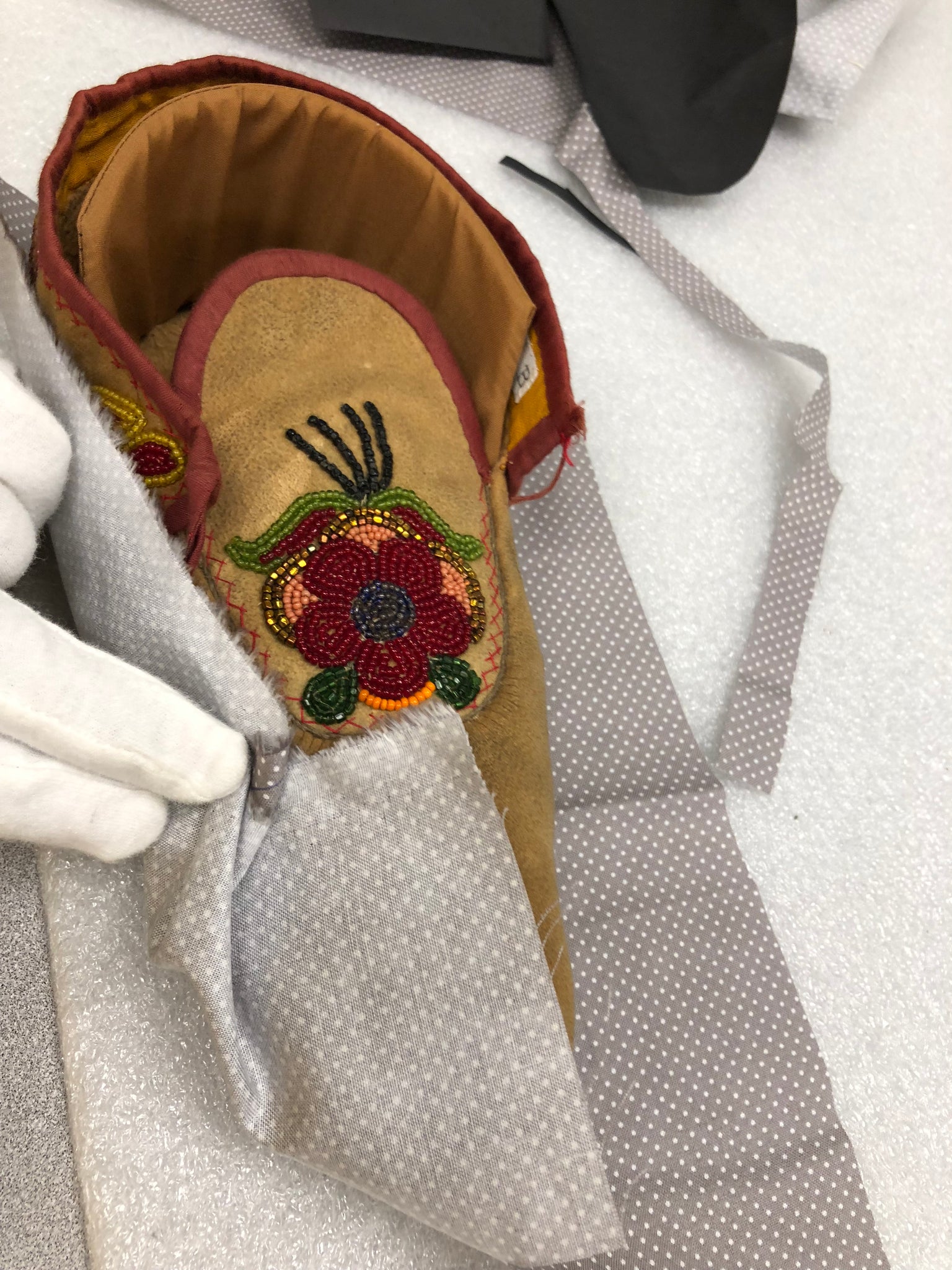 "Nookomis Obagijigan" is touching 150 year old moccasins