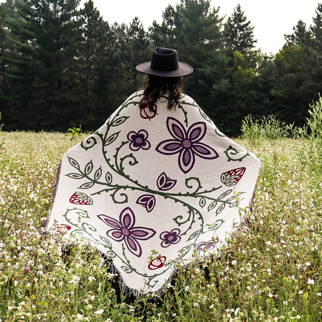 Light variant of Woodland Floral Throw in a field of flowers. 